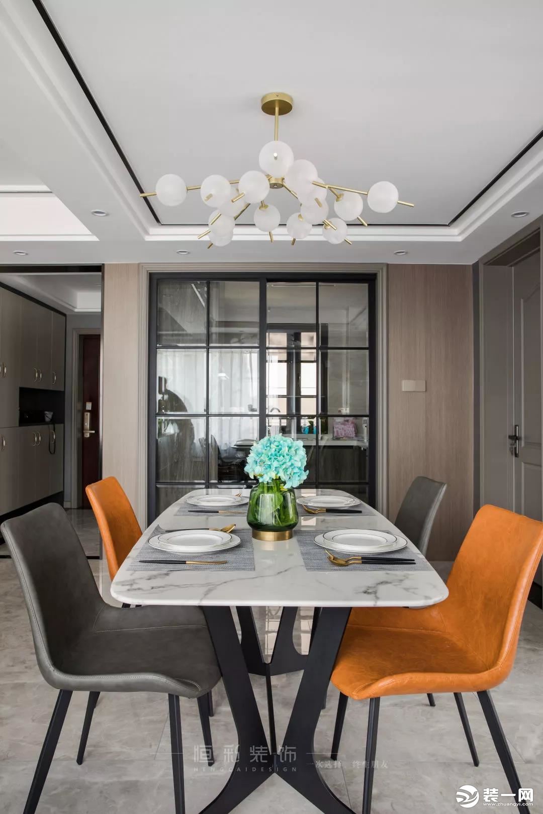  餐厅空间简洁大方，黑白灰餐桌椅的配色简单大气，橙色餐椅起到跳色的作用，既提亮了空间色彩，又与客厅的