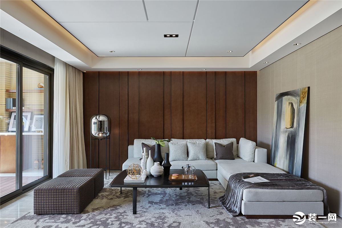 客厅以胡桃木为背景，搭配上灰色布艺沙发与地毯，地面布置小茶几，让客厅显得简约实用而舒适。      