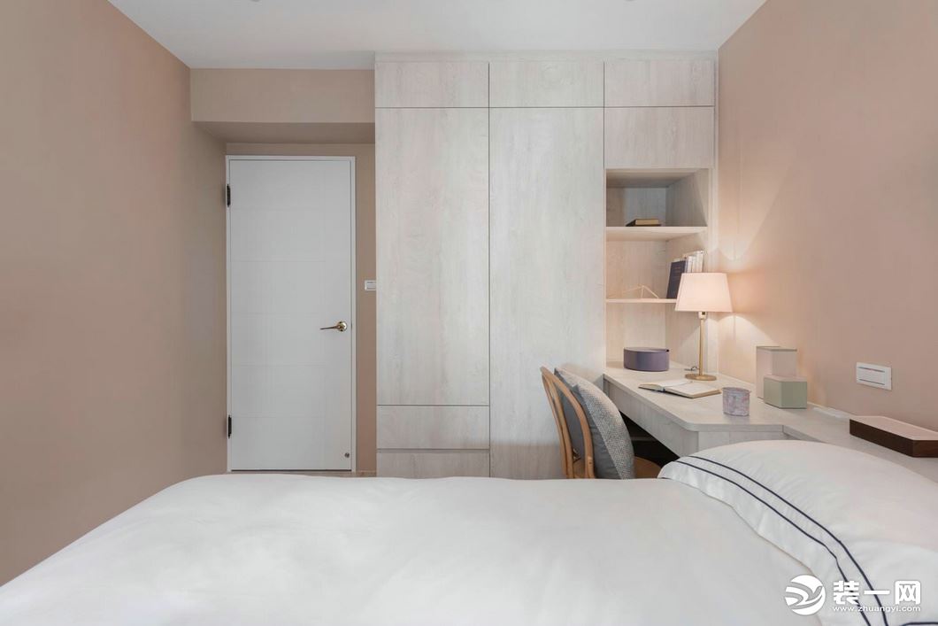 卧室墙壁是浅粉色的壁纸，十分小清新，左侧的书桌连接衣柜的设计，方便实用