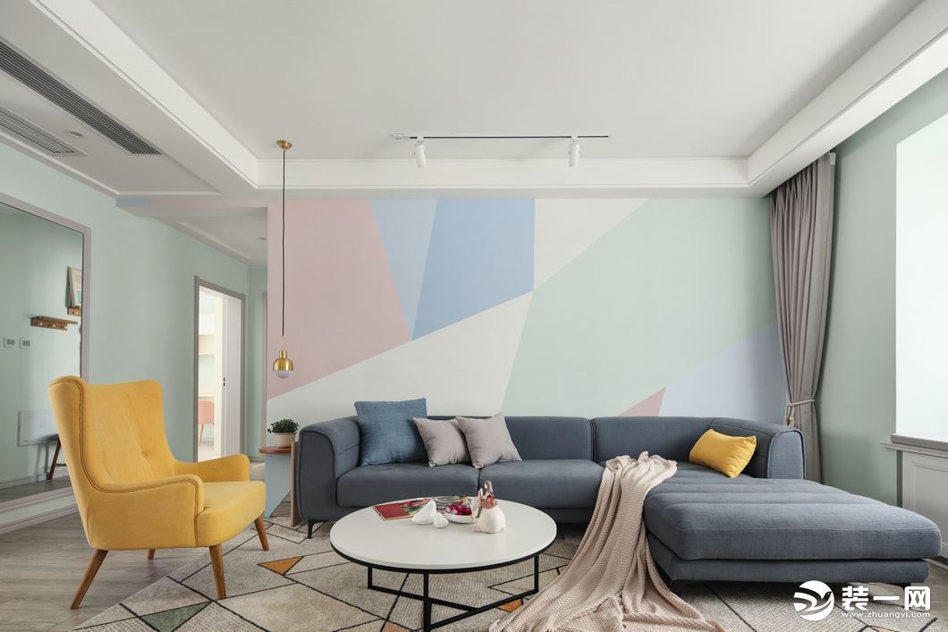 整个客厅运用了大面积灰度绿色系，搭配低饱和度的拼色墙纸营造了一种可被治愈的温柔感。