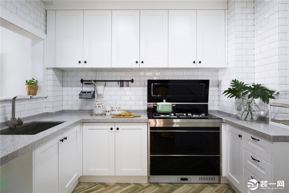 清新的整体氛围也同样延伸到了厨房， 橱柜与台面的大片纯白设计显得干净整洁，白色方格砖让空间增添现代感