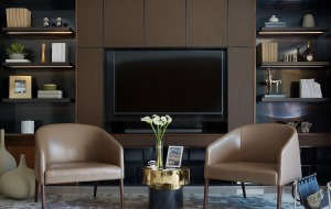 电视背景墙有棕色为主，两侧的空间做成了收纳柜的设计以黑色为底色，沉稳而有格调