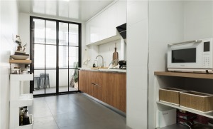 厨房采用白色为主色调，显得格外干净、整洁。选用木质橱柜，也为这个空间增添了些许相同的复古元素。