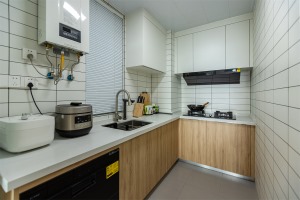 原木色橱柜搭配米白色操作台，颜值很高且实用。同时在不大的厨房里合理安排电器，洗碗机烤箱油烟机无痕安装