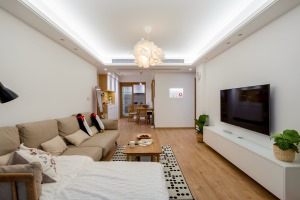 客厅宽敞明亮，整个空间都使用木地板，墙面洁白看着非常舒适。