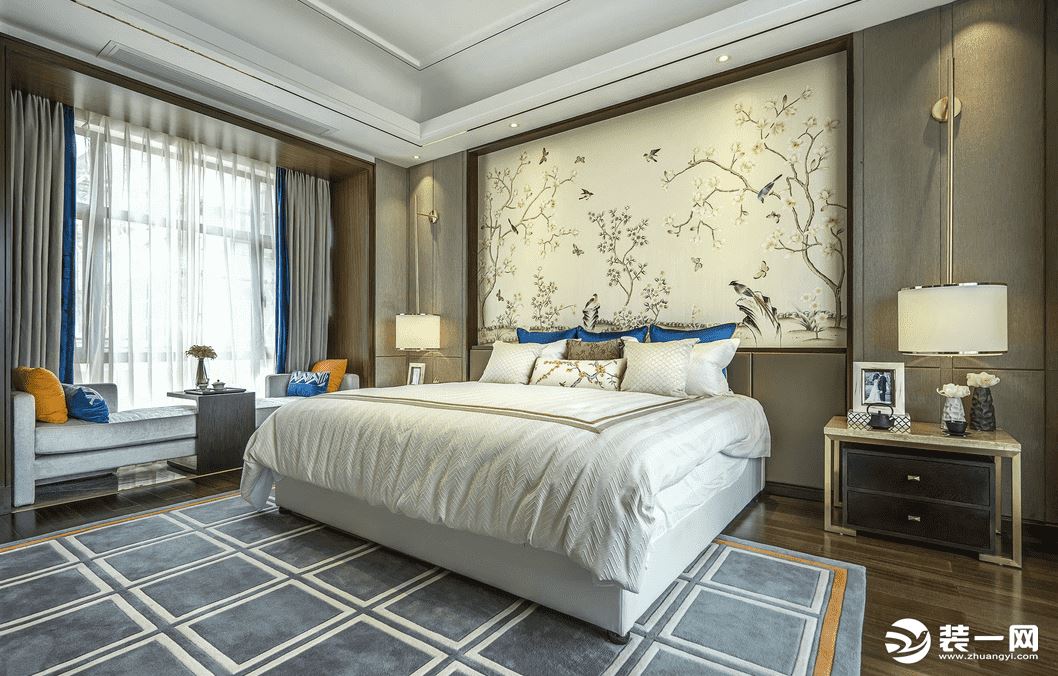 合景天汇广场中式风格案例-卧室效果图。 卧室以米灰色为主，黄、蓝色的枕头来对比，挂画采用古香古色的中