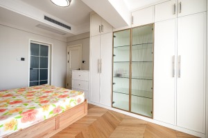 定制的衣柜，中间选用透明的玻璃门，让房间多了些精致感和透气感。