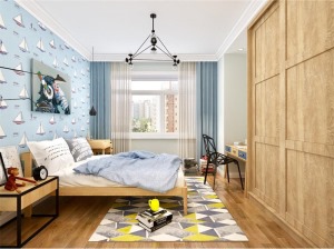 次卧室是北欧风格的儿童房，整体墙面是蓝色壁纸，床架、床头柜、衣柜包括书桌都是木色。
