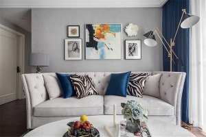 客厅的主要色调为灰蓝色，灰色的地毯，灰色的墙面，米白色的美式布艺沙发，充满活力，积极向上。