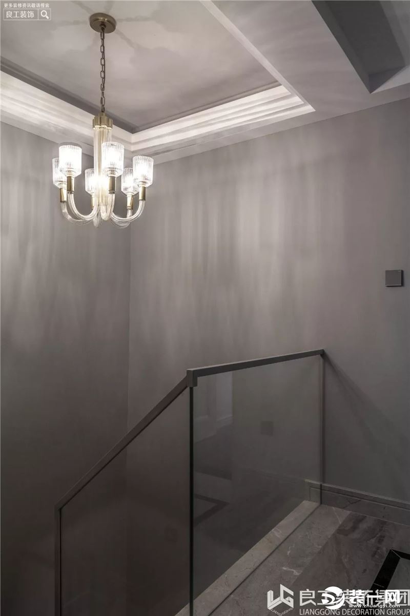 楼梯的墙面和扶手都是以灰色为主，和餐厅的墙面色彩相同并形成整体，美式曲线型吊灯充满了艺术感