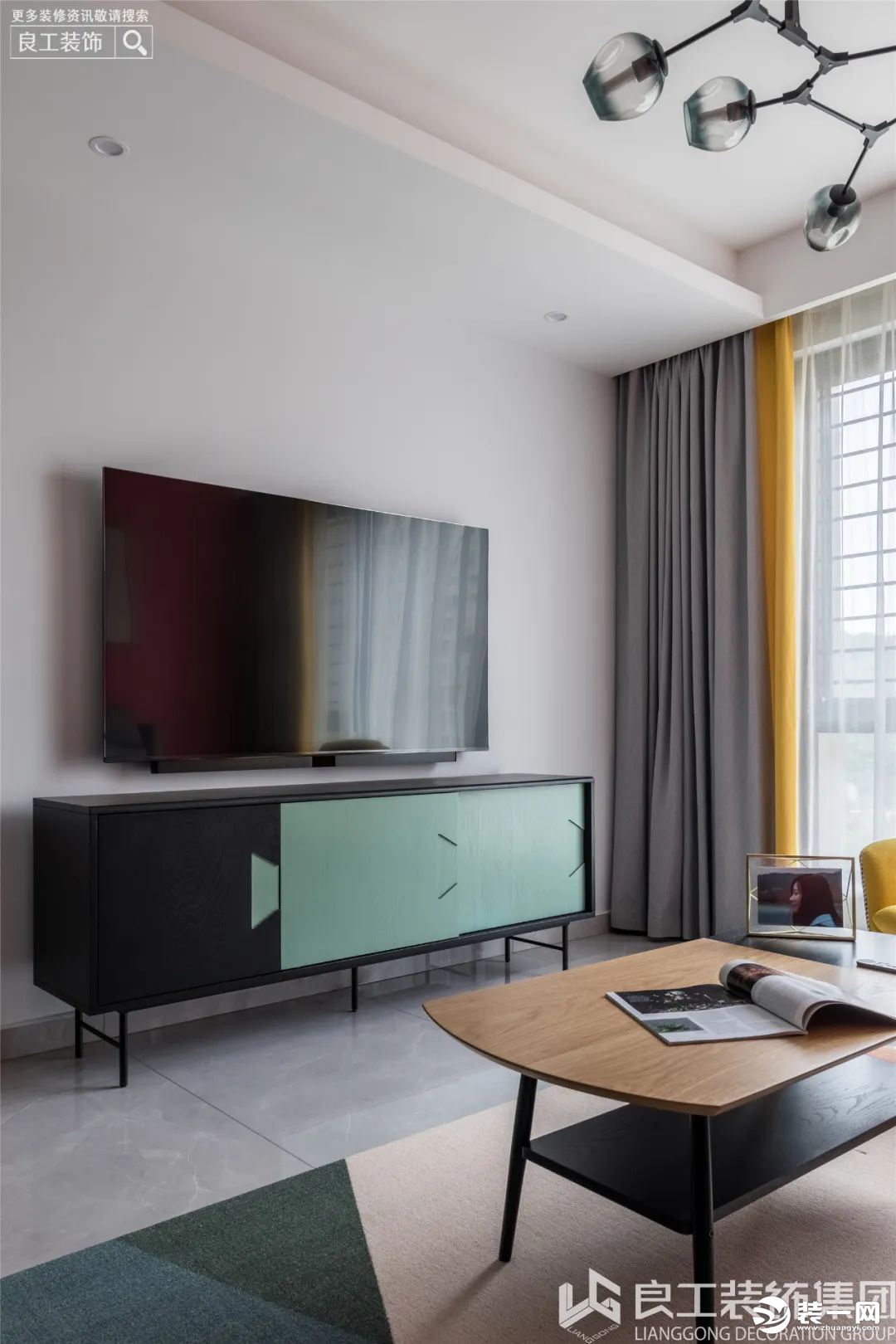 电视背景墙选用了纯色——淡灰，用黑、蓝撞色的时尚电视柜来丰富墙面，增加了空间的层次感