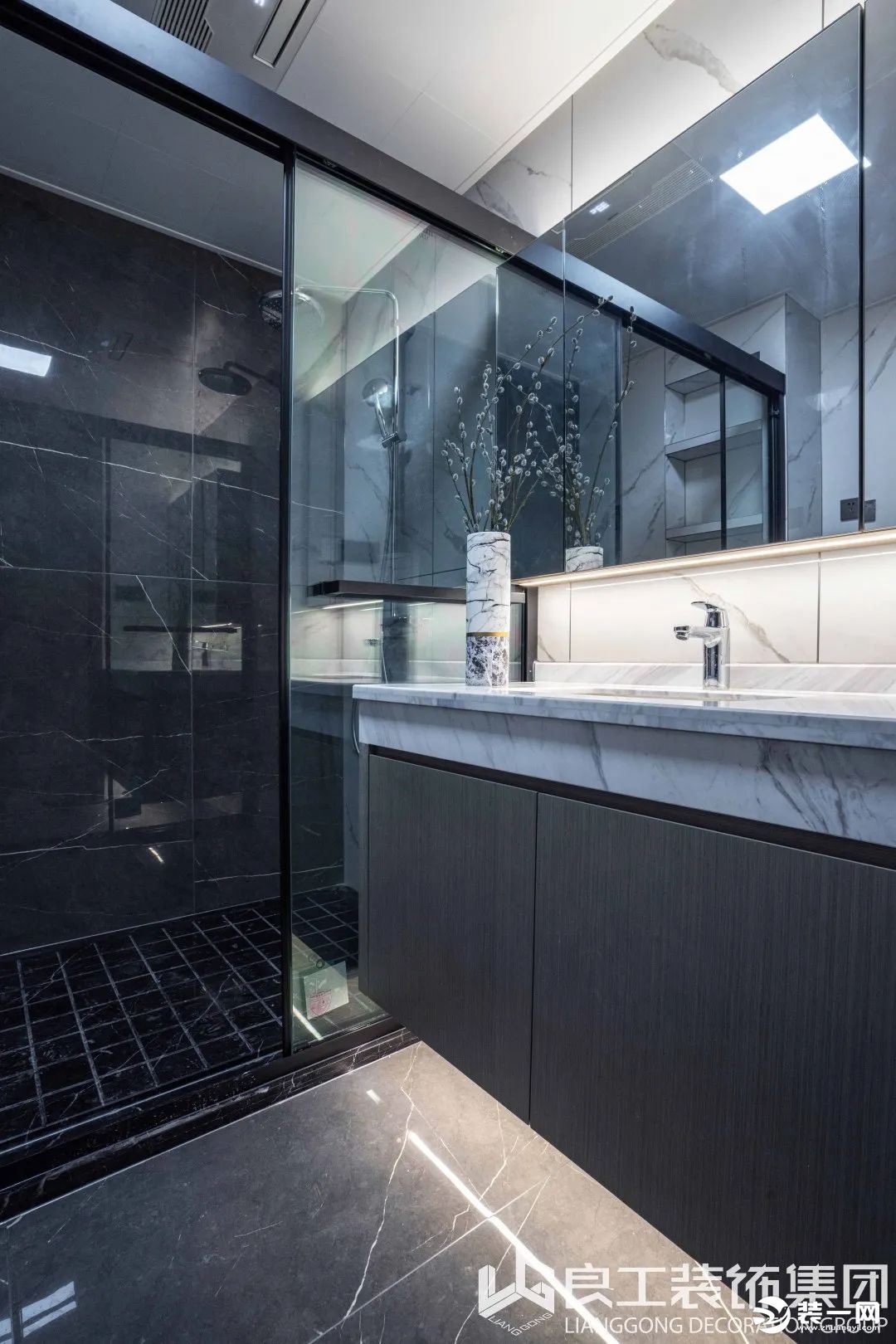 卫浴空间延续了简约的黑白灰调，干湿区以不同纹理与色系的大理石瓷砖区别铺陈，补充了空间的单调设计