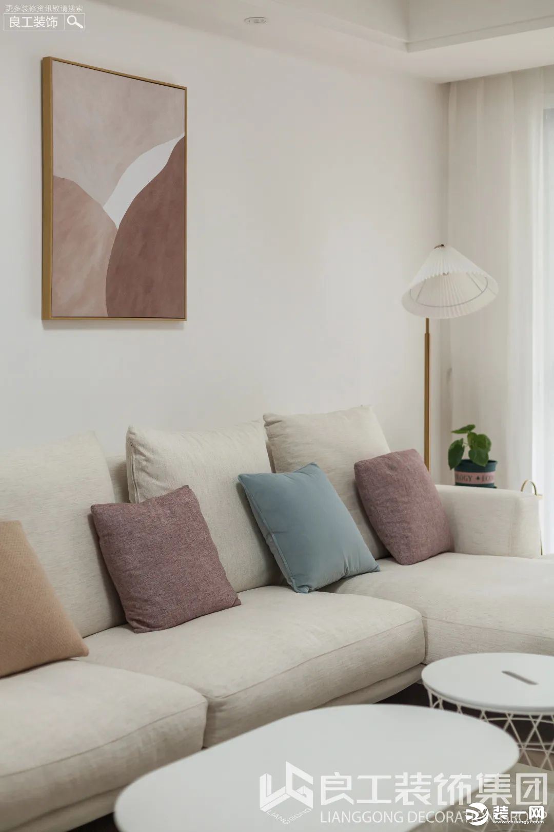 米白色系的转角沙发以简单的方式诠释了家的温柔，莫兰迪色系的靠包与墙画，成为了平衡客厅空间色彩的点缀