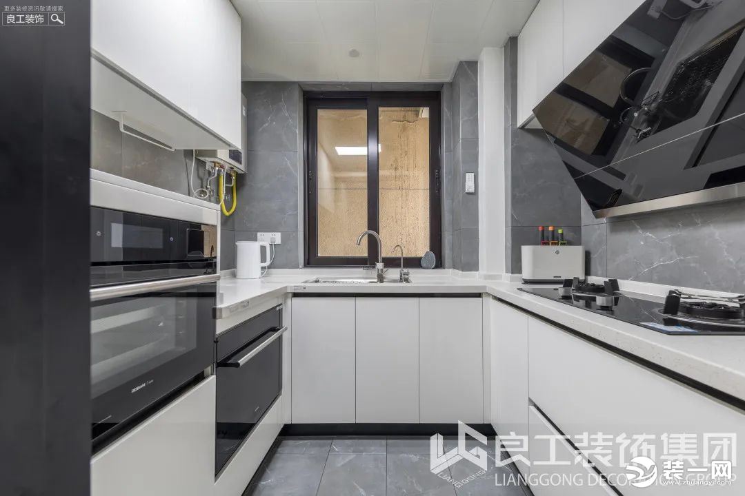 厨房空间打造成了黑白色调，白色的烤漆柜体与磨砂质感的台面完美契合，搭配深灰色花纹墙砖，时尚大气