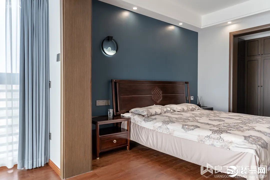 藏蓝色的背景墙，温润优雅，颇具宋明风骨，与寝具素雅简练的气质相得益彰