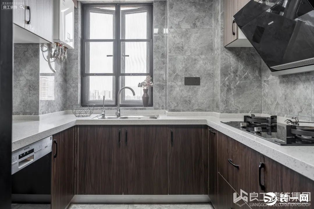 厨房是U形设计，开阔大气，柜体棕色的木质纹理淳朴清新，配上渐变灰色花纹墙砖，整体搭配低调而不失格调