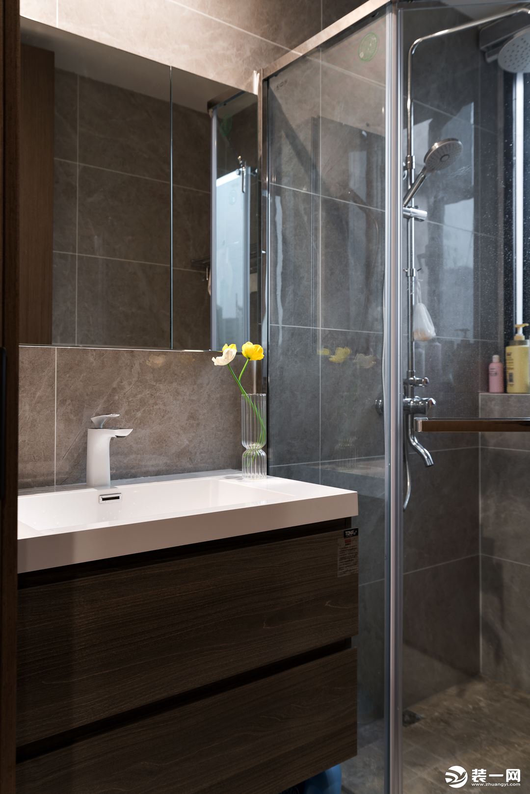 卫浴空间采用了气质灰调，搭配温润的木质柜体，不动声色流露出现代都市摩登感。