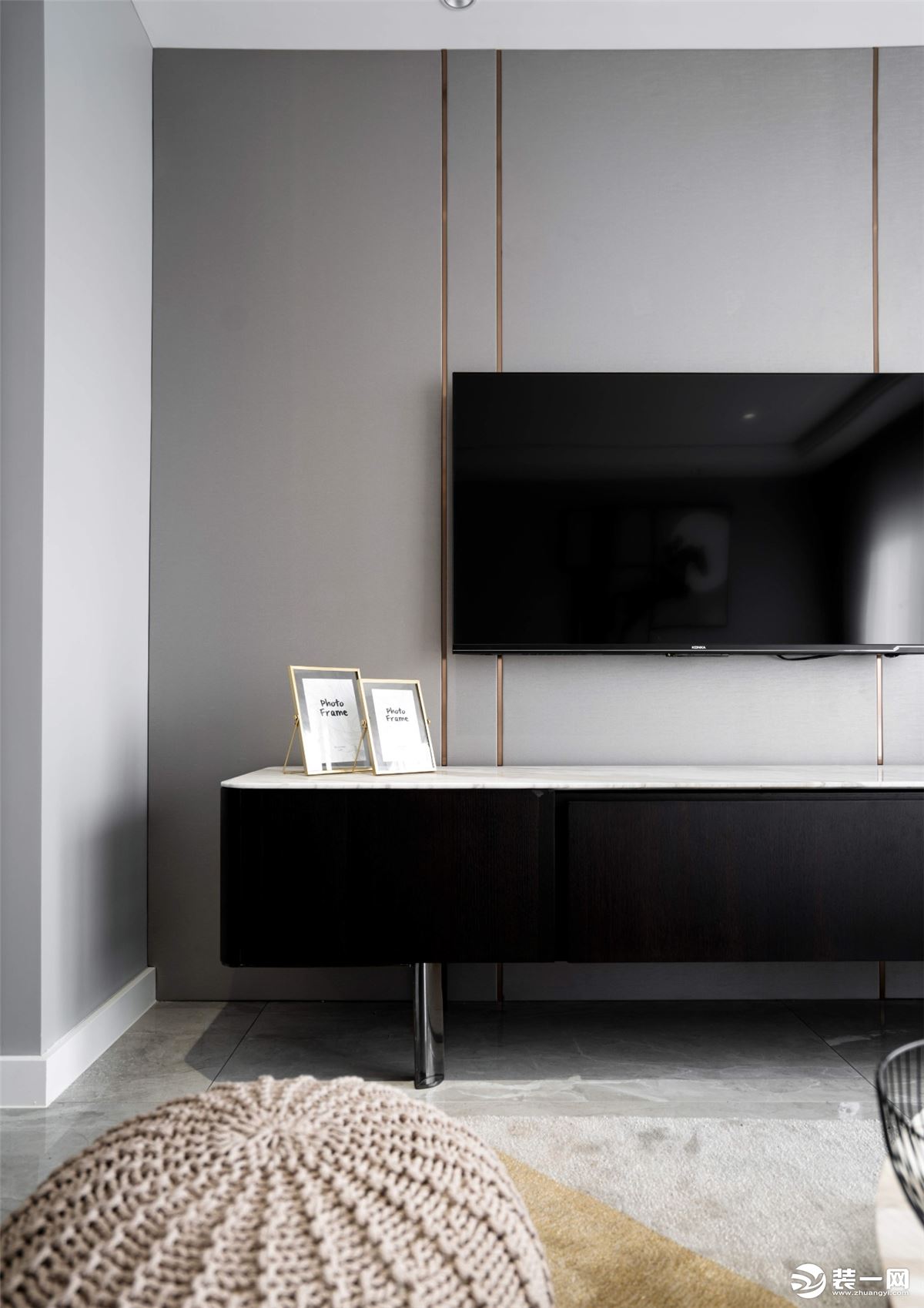电视背景墙是灰色和金色线条的搭配，干净利落。