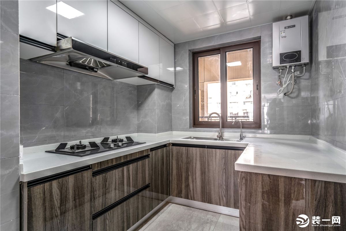 半U型厨房采光较好，灰色大理石地面、墙面使空间更加宽敞明亮，假原木的橱柜搭配白色台面，简单清爽。