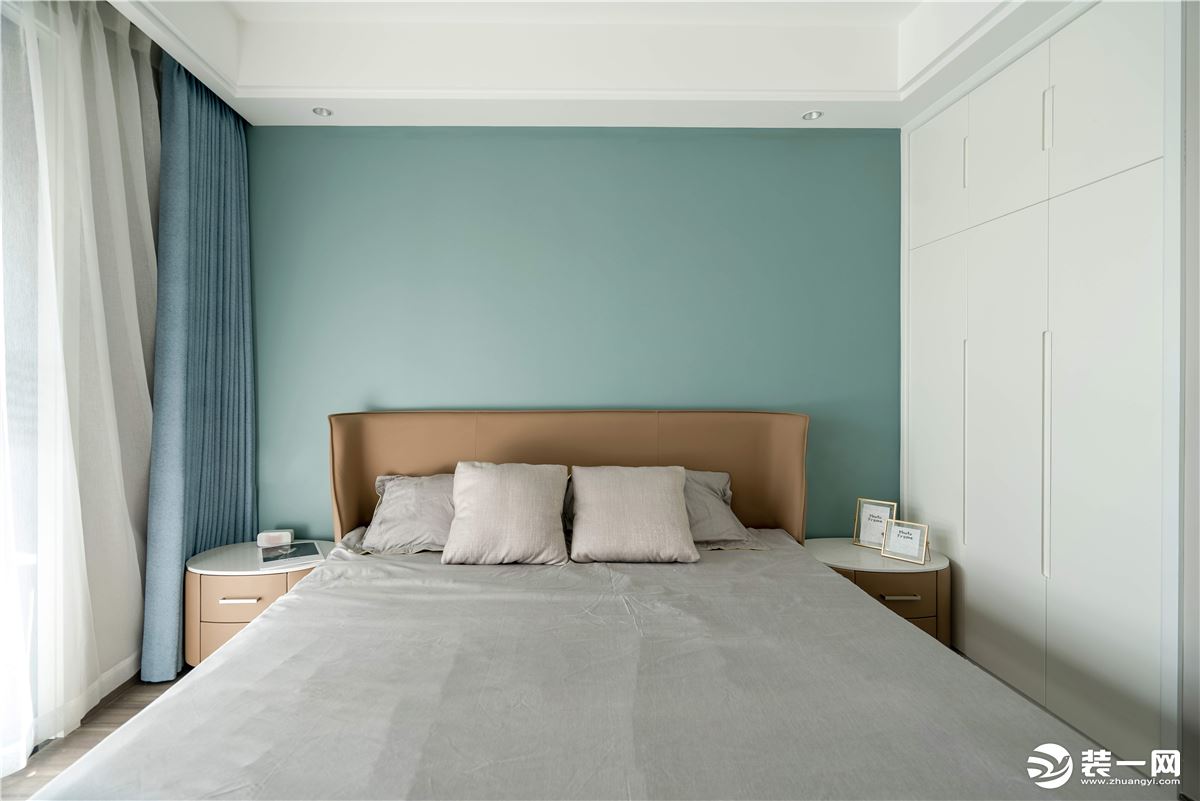 卧室色彩相对丰富，莫兰迪色的背景搭配棕色皮床，舒适的同时简练而有层次感。
