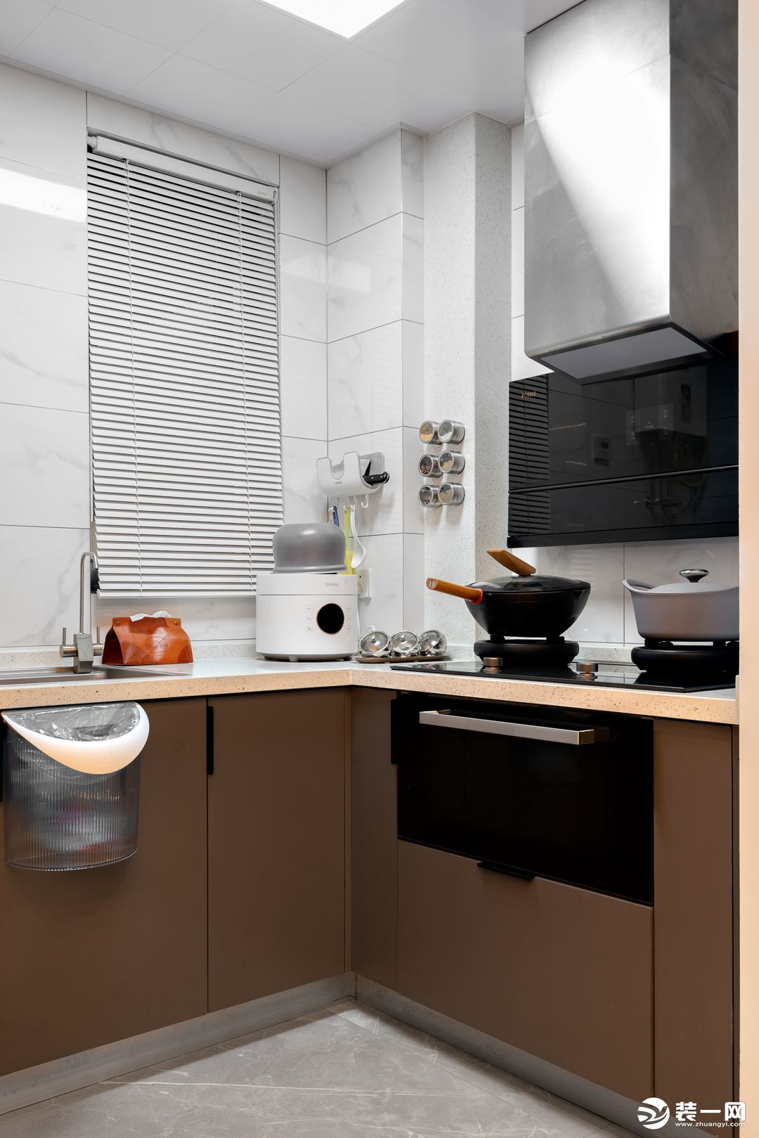 厨房整体以浅色系搭配，有效减弱空间的压抑感。但下柜则采用了深色系配色，从而能与客餐厅偏深的木色调进行