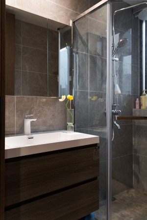 卫浴空间采用了气质灰调，搭配温润的木质柜体，不动声色流露出现代都市摩登感。