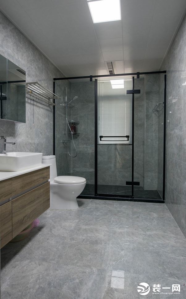 卫生间墙面采用灰色系墙面砖，搭配原木色浴室柜，质感十足，增加淋浴隔断，保证卫生间干燥、卫生，方便清理