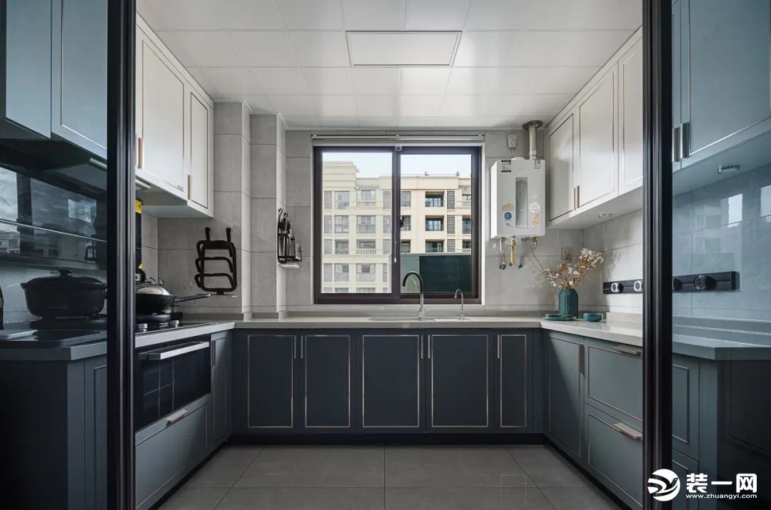 厨房U字型的设计，最大化利用空间，增加储物功能，柜体则是白和深灰的碰撞，与客厅餐厅空间相互呼应。