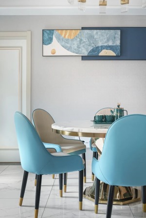 餐桌为圆形餐桌，理石台面增加了整体的质感，餐椅采用蓝色调颜色点缀，在不经意间也和整体色调相呼应。