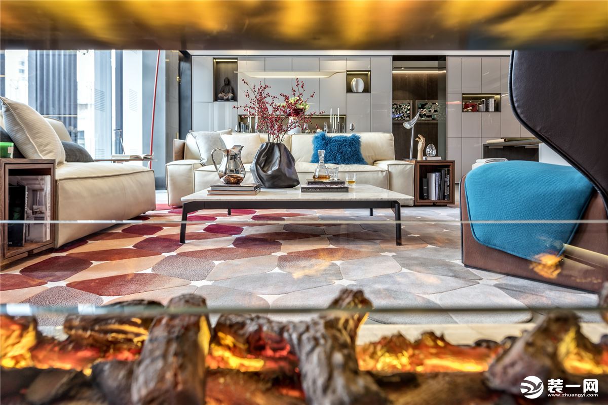 本案客厅和餐厅在一个空间， 客厅的部分相较于传统客厅更为自由随性，设计师选用红色的落地灯配合地毯的色