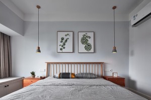 卧室一派舒适的木地板，两幅植物挂画，床头两边各一盏文艺感十足的水泥吊灯，没有繁复的色彩，没有多余的装