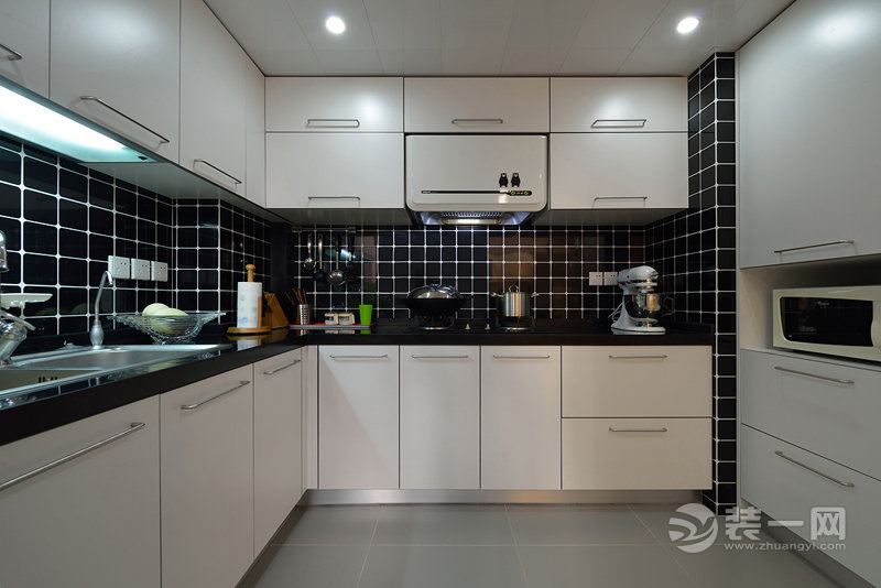 在设计厨房的时候根据业主的要求打了许多橱柜，象牙白的橱柜搭配黑色瓷砖，经典的黑白配让厨房看上去十分有