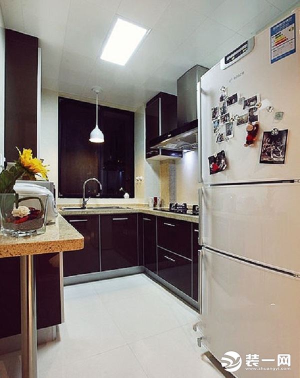 厨房空间比较注重功能性，浅色地砖看起来干净舒适也很容易清理，深色的橱柜和烟机点缀环境，小空间大功能，
