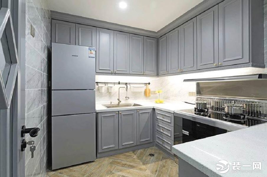 【厨房装修效果图】灰色是一个整体，就连冰箱也配合着一起，平整衔接台面的炉灶的设计证明了这就是现代人的