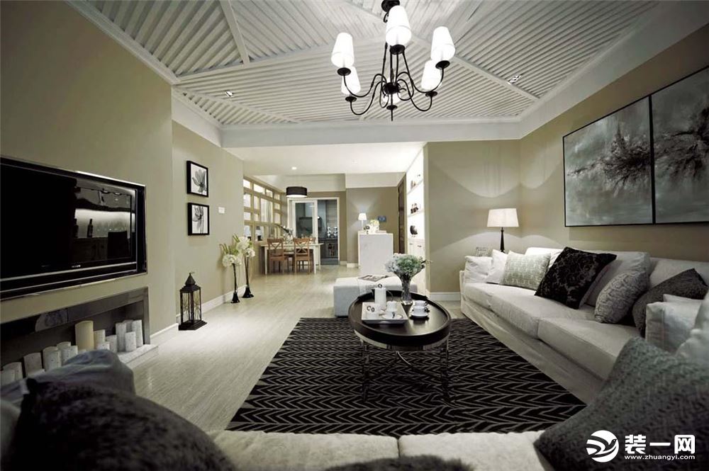 客厅主要以黑白灰为主色彩，米白色的沙发组合上摆放着许多黑、灰色抱枕，既温馨又颇具质感。