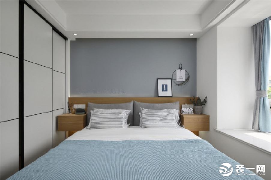 简单的卧室结构，灰白蓝相间，木色床头柜更显自然色调，看起来空间狭窄，但是整齐有致，飘窗紧靠床边，可随