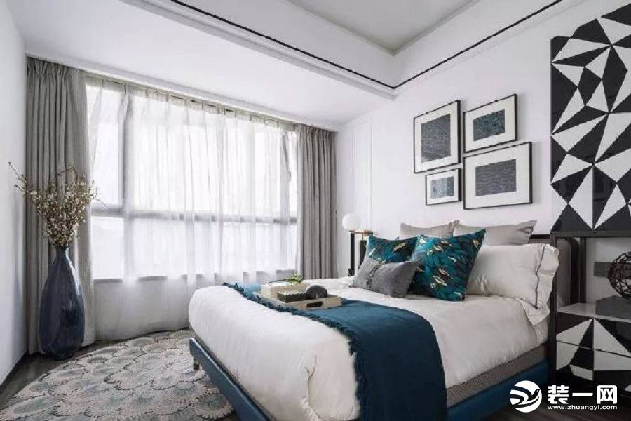 黑白相间的床头柜，大小相间的挂画，独特而淡雅的地毯，优雅紫的大花瓶，灰白窗帘的组合，构成了卧室的现代