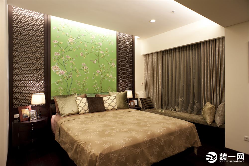 卧室的设计有着独特的新古典式的风格，床头木质雕花与绿色背景墙面极富装饰性，红木地板增添了几分温暖，绸