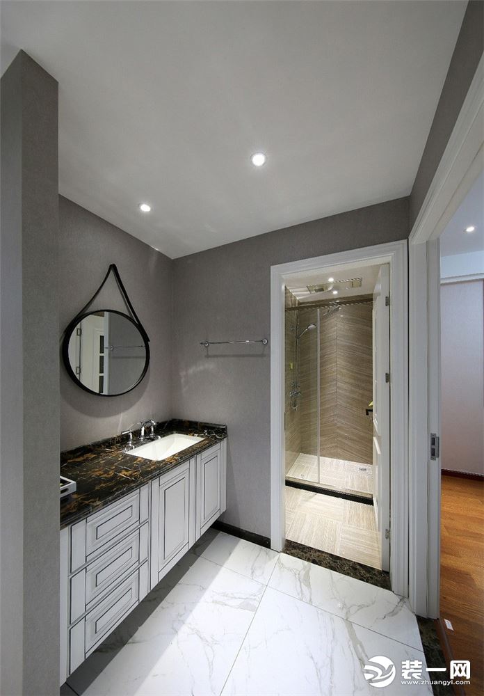 卫生间有着干湿分离的两个空间，高级灰的墙面，小小的圆形挂镜，宽敞的浴室柜作为收纳，让整个空间看起来干
