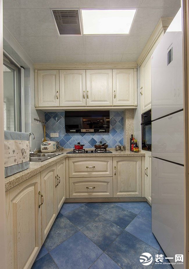厨房有蓝色地面砖，仿佛置身于海边，白色的橱柜为整个厨房带来了干爽洁净，宽敞的空间，营造出一个情调而又