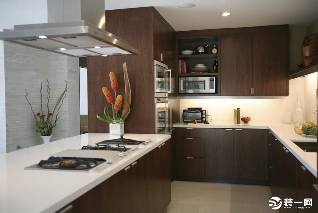 深色的橱柜更显质感，半开放式的厨房能实现空间的交流，时尚又大气。明亮的灯光照射下来，使整个厨房变得温