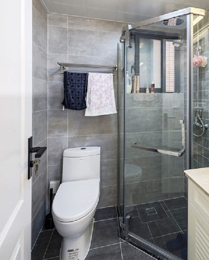 卫生间通过玻璃门对淋浴区与洗漱坐便分隔，形成小型的区域划分，保证使用功能，从地到墙，从深到浅。
