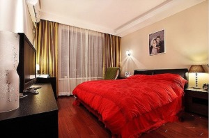 红木地板与黑漆家具相搭配，使整个空间更典雅，床单的大红不仅没有突兀反而更添甜蜜感；灯光的设计很巧妙，