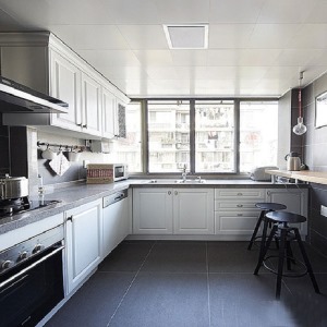 厨房是一个很容易弄脏的一个空间，所以设计师结合这个空间的采光良好，选用深色的地砖和深色的面板搭配着白