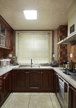 厨房深沉的颜色使得空间气氛比较安静舒缓，但是并不会死板或是压抑，设计师用深浅不一的墙砖正斜两种方法铺