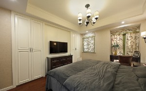卧室陈设简约，双开门带来不同的居住体验，花色布艺与暖白色的墙面相互融合，于细节处彰显优雅生活，细数光