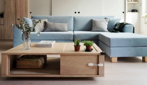 蓝色线条分明的布艺沙发，浅灰色的抱枕，与木质四方形茶几，温馨舒适