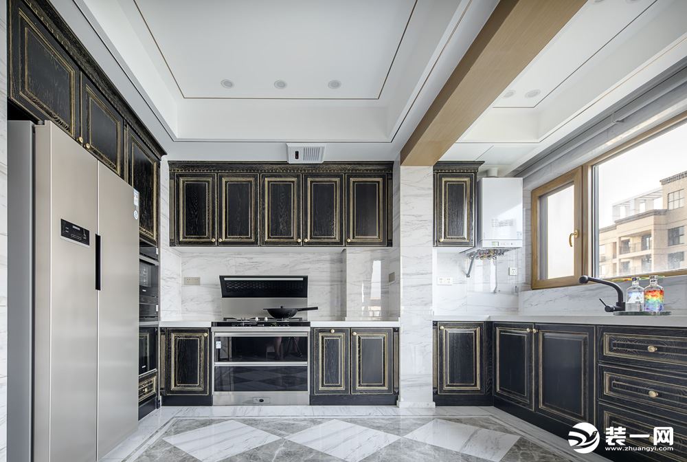 L型布局呈现的厨房，黑色与金色的点缀，搭配大理石台面，简洁清爽，略带高低差的清理台的设计更符合人们日