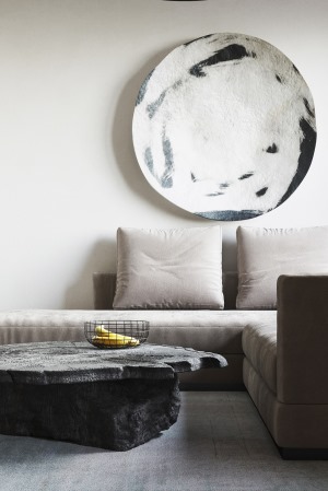 米色的布艺沙发搭配落地台灯，墙面的圆形装饰，构成了客厅简易的空间