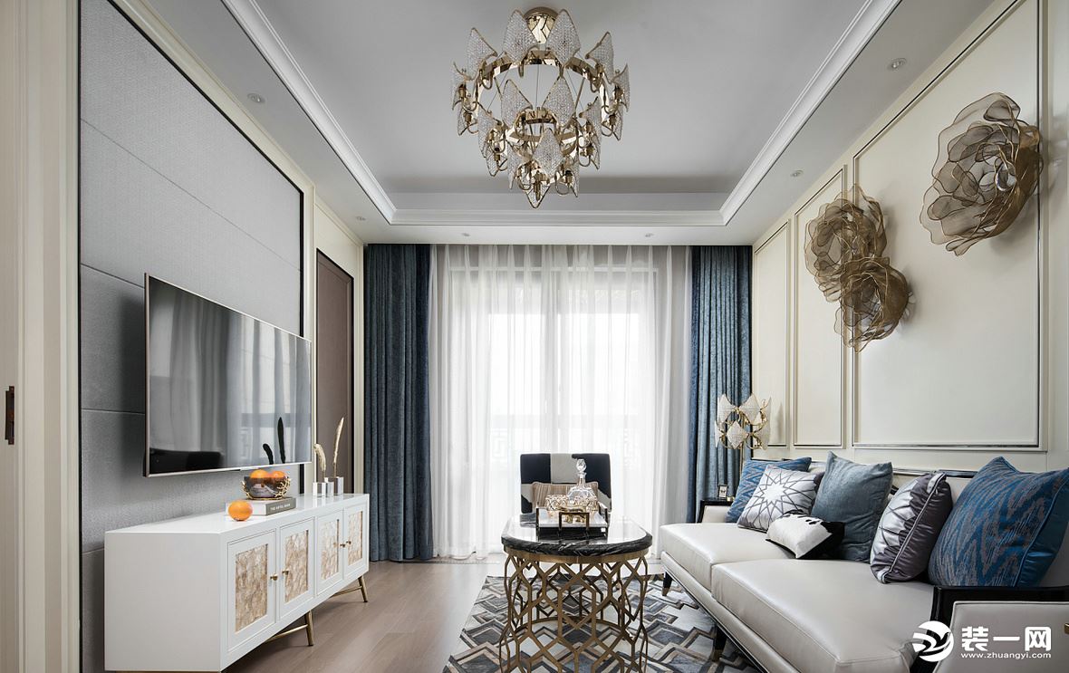 客厅以浅色调为主，黄铜与浮雕的设计， 搭配水晶吊灯的点缀，为空间点缀华丽与明亮。
